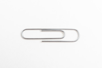 A horizontal macro shot of a common paper clip set on a white background.