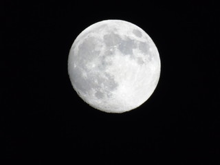Genova, Italy - 03/20/2019: An amazing photography of the full moon over the city of Genova by night with a great clear sky in background and some stars