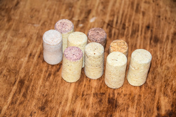 several old wine corks stand on wooden background side