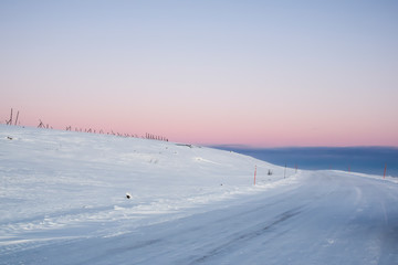 Fototapeta na wymiar pink dawn in the tundra everywhere white snow nobody road