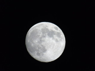 Genova, Italy - 03/20/2019: An amazing photography of the full moon over the city of Genova by night with a great clear sky in background and some stars