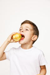 Little boy is eating apple studio shot 