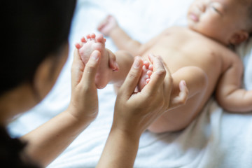 Baby foot massage by mom hand after shower