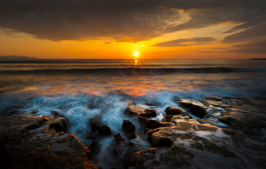 raging sea at sunset taken with long exposure