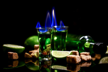 absinthe in glass with lime slices on dark background. absinthe poured into a glass.absinthe poured into a glass. free space for text. the concept of elite alcohol