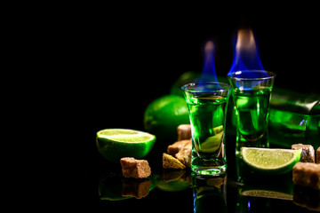 concept of elite alcohol. absinthe poured into a glass. burning sugar. in the background is a...