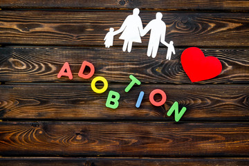 adoption copy and figures on wooden background top view