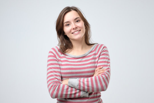Smiling young caucasian woman with her arms folded