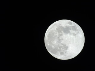 Genova, Italy - 03/20/2019: An amazing photography of the full moon over the city of Genova by night with a great clear sky in background and some stars