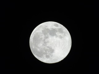Genova, Italy - 03/20/2019: An amazing photography of the full moon over the city of Genova by night with a great clear sky in background and some stars