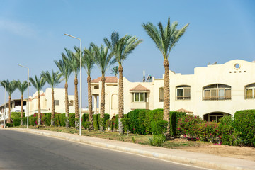 The interior of the hotel, two-story houses among the palm trees
