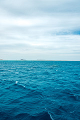 Obraz premium minimalistic seascape, blue sea and sky with white clouds on the whole frame