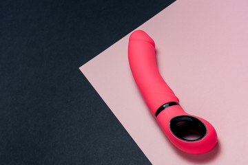 Erotic pleasure toy on a black background. Sex gadget and masturbation device. A pink rubber and...