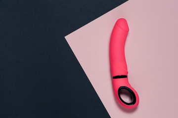Erotic pleasure toy on a black background. Sex gadget and masturbation device. A pink rubber and...