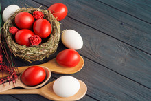 Easter background with dark red Easter eggs and spring flowers. Top view with copy space 