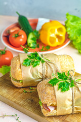 Sandwich with ham, tomato, cheese, pepper, onion and salad