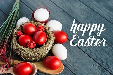 Easter background with dark red Easter eggs and spring flowers. Top view with copy space 