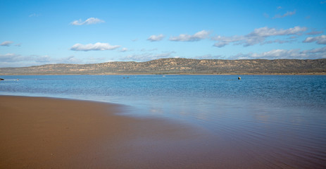 Clouds reflecting in the water on isthmus of sand between Pacific ocean and the Santa Maria river at the Rancho Guadalupe Sand Dunes Preserve on the central coast of California United States