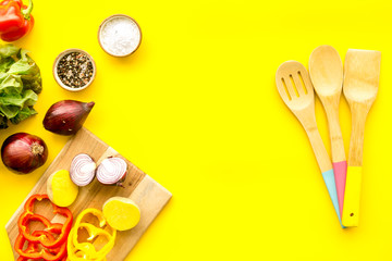 Fresh food ingredients for vegetarian kitchen on yellow background top view