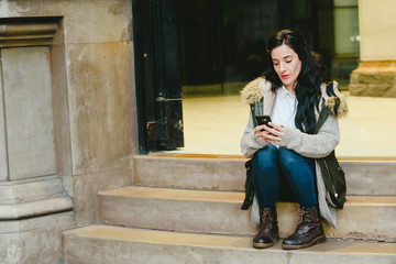 Middle-aged woman answering a call on her cell phone in the street.