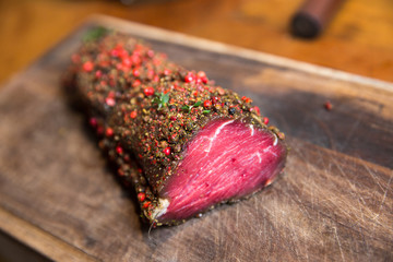 Raw beef marinated in spices. Fresh beefsteak in marinade of pepper and herbs