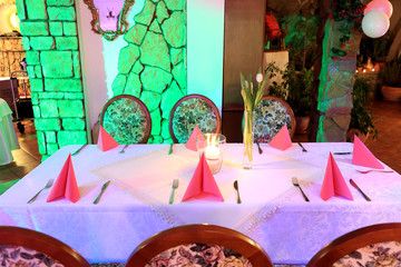 Stół nakryty w restauracji, różowe serwetki.