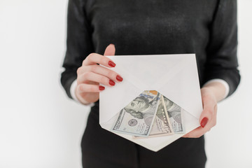 Woman holding money and using smartphone.