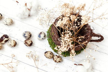 Easter decoration with egg in nest cup on white wooden background. Easter concept. Flat lay top view copy space. Spring greeting card