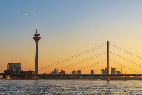 Outdoor scenery of Düsseldorf City skyline, downtown, tower bridge, riverside and Rhine River, and beautiful background of gradient sunset sky. 