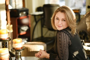 Beautiful 50-year-old woman in the background of a beautiful sunset light through the windows