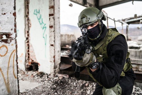 Special forces police soldier in action battle ruined building aiming riffle