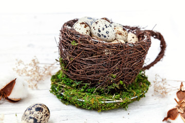Obraz premium Easter decoration with egg in nest cup and cotton on white wooden background. Easter concept. Flat lay top view copy space. Spring greeting card