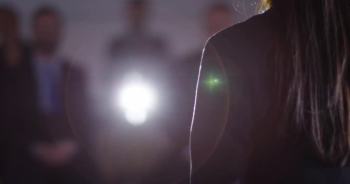 4K Businesswoman giving a presentation to colleagues in dark conference room