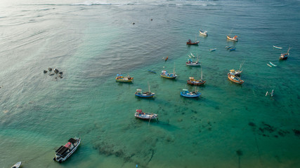 Aerial view of beautiful crystal clear ocean seascape with fishing boats in the coast