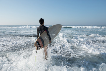Woman surfer with surfboard going to surf