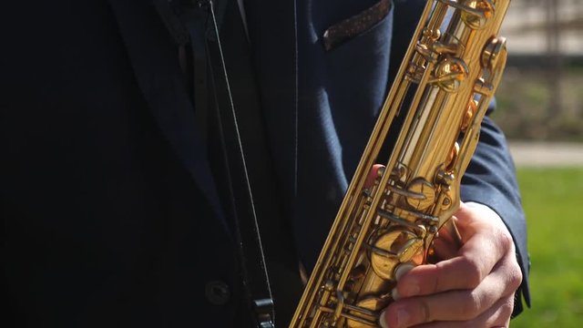 musician plays the blues wind instrument. man playing saxophone jazz music. Saxophonist in dinner jacket play on golden saxophone. Live performance. close-up