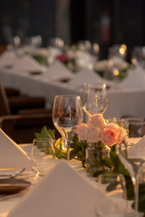 Champagne glass and beautiful flowers on the dining room table in a luxurious room with warm lighting