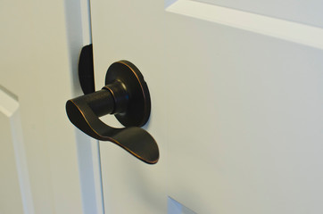 A bronze style flat bar handle on the white door in the new showroom. 