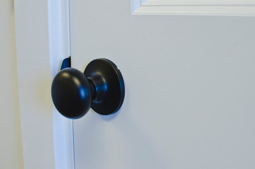The small dark round handle on the door in the new office area. 