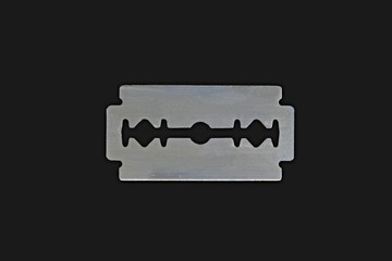 Safety razor blade on a black background. Stainless steel double edge blade, isolated on black...