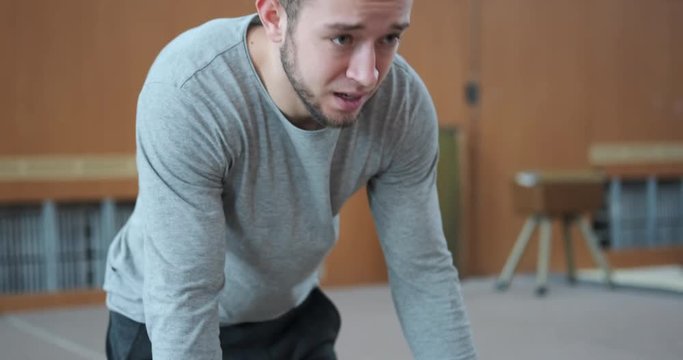 Athlete performing planche and handstand exercise on parallel bars at the gym