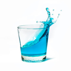 Glass with blue liquid and water splash