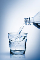 Water in bottle poured into glass. World Water Day