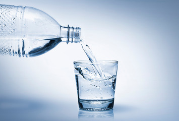 Water in bottle poured into glass. World Water Day