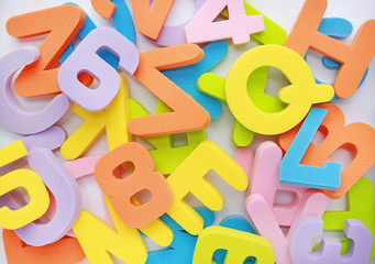 Messy heap of sponge rubber alphabet letters background.