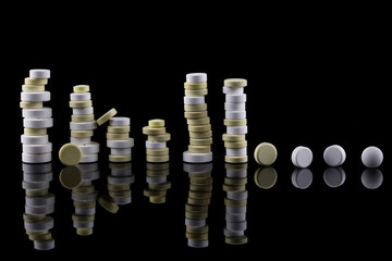 Yellow and white medicinal tablets on a black background
