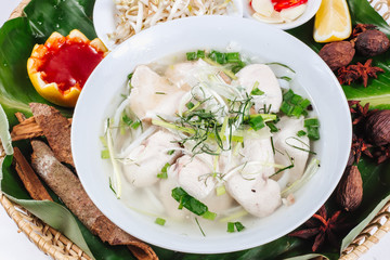 Traditional oriental cuisine of  Vietnam. Soup pho ga with rice noodles, chicken, pepper, wheat germ, greens