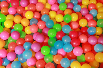 Fototapeta na wymiar Many colorful plastic balls in a kids' ball pit at a playground.
