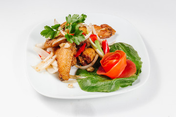 Traditional oriental cuisine of  Vietnam. Breaded Chicken Wings with green salad and tomato