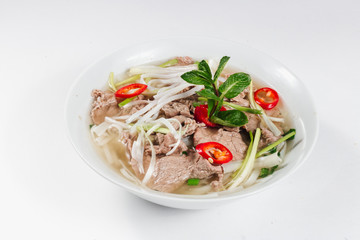 Traditional oriental cuisine of  Vietnam. Pho bo soup with rice noodles, beef, pepper, wheat germ, greens